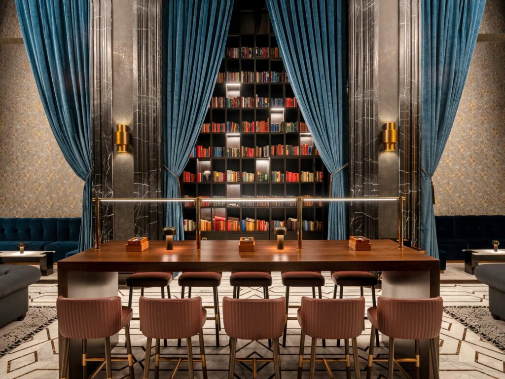 The library at the Raffles Doha has collected over 40,000 books with first editions and
timeless classics including Robinson Crusoe from 1785 and Moby Dick from 1811.
Rich wood panelling, leather-bound books, and comfortable seating create an
atmosphere that encourages lingering over fine whiskeys and engaging conversations.